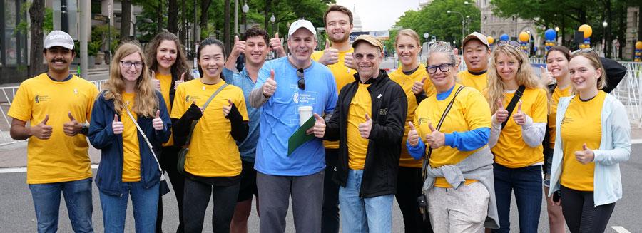 Group picture of people smiling outside at the Race for Hope DC, with Mark Gilbert in the middle