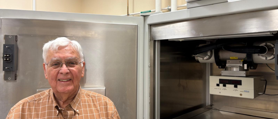 Jim Mitchell in front of a machine and a sign that says X-ray on