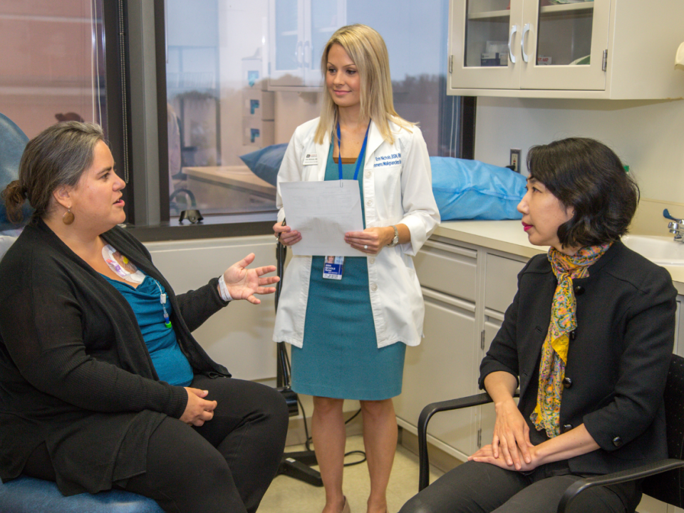 A patient speaks with a CCR nurse and scientist-physician