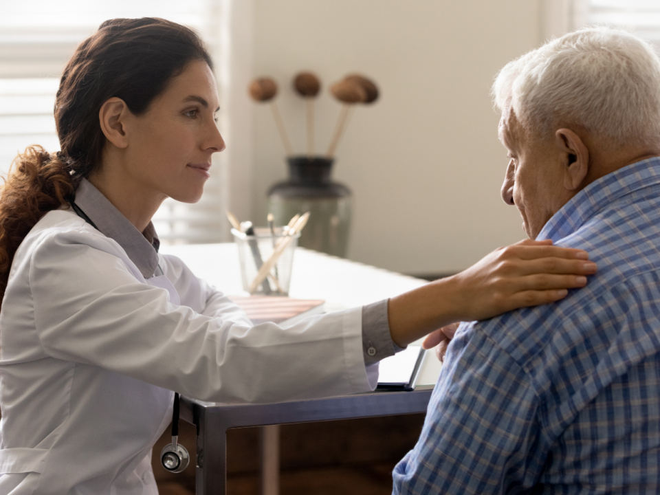 Caring female doctors supporting older male patient