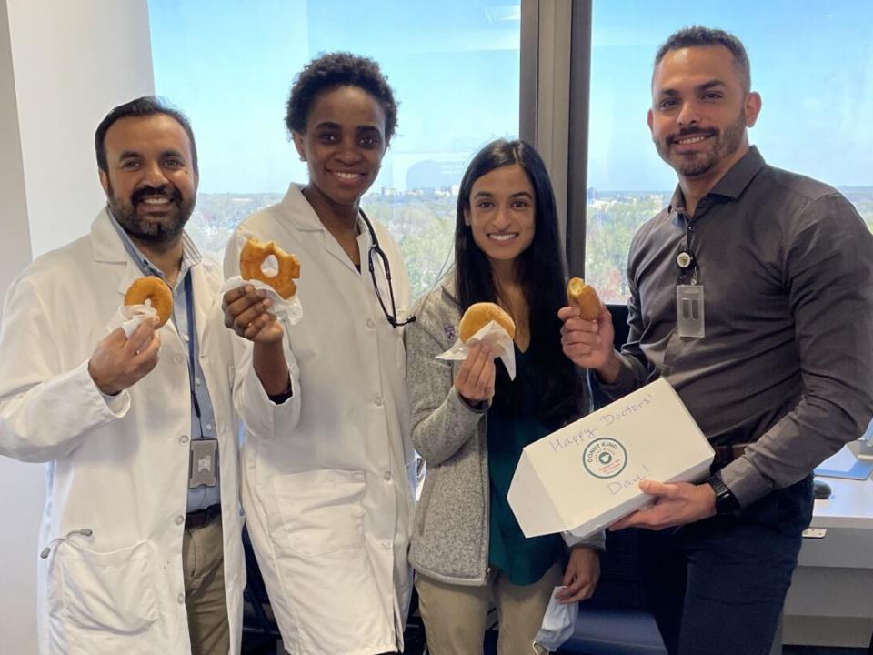 Fellows standing together with doughnuts