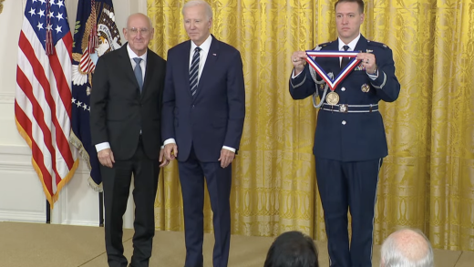 Steven Rosenberg, M.D., Ph.D. (left), receiving the National Medal of Technology and Innovation from President Joseph Biden (middle). The medal is being presented by a military aide (right).