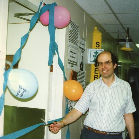 Howard A. Young, Ph.D., cutting the ribbon to celebrate the opening of his lab in the 1980s.