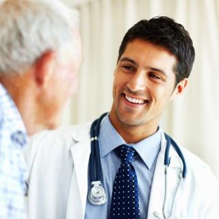 Young male doctor with an older male patient. 