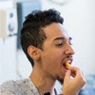 Joel Rodriguez enjoys a French fry.