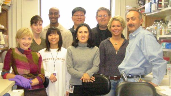 Image caption: The Keller Lab in 2003. Left to right: Masha Drutskaya; Kimberly Klarmann; Ben Asefa; Wilairat Leeanansaksiri; Hyung Chan Suh; Mariaestela Ortiz; Jonathan Keller; Katie Renn; John Gooya.