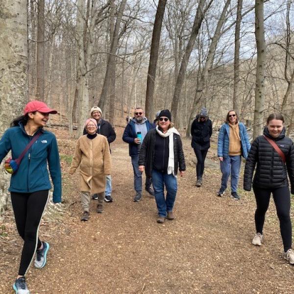 Several members of the pediatric oncology branch are walking down a hiking path in the forest in Maryland in March 2023.