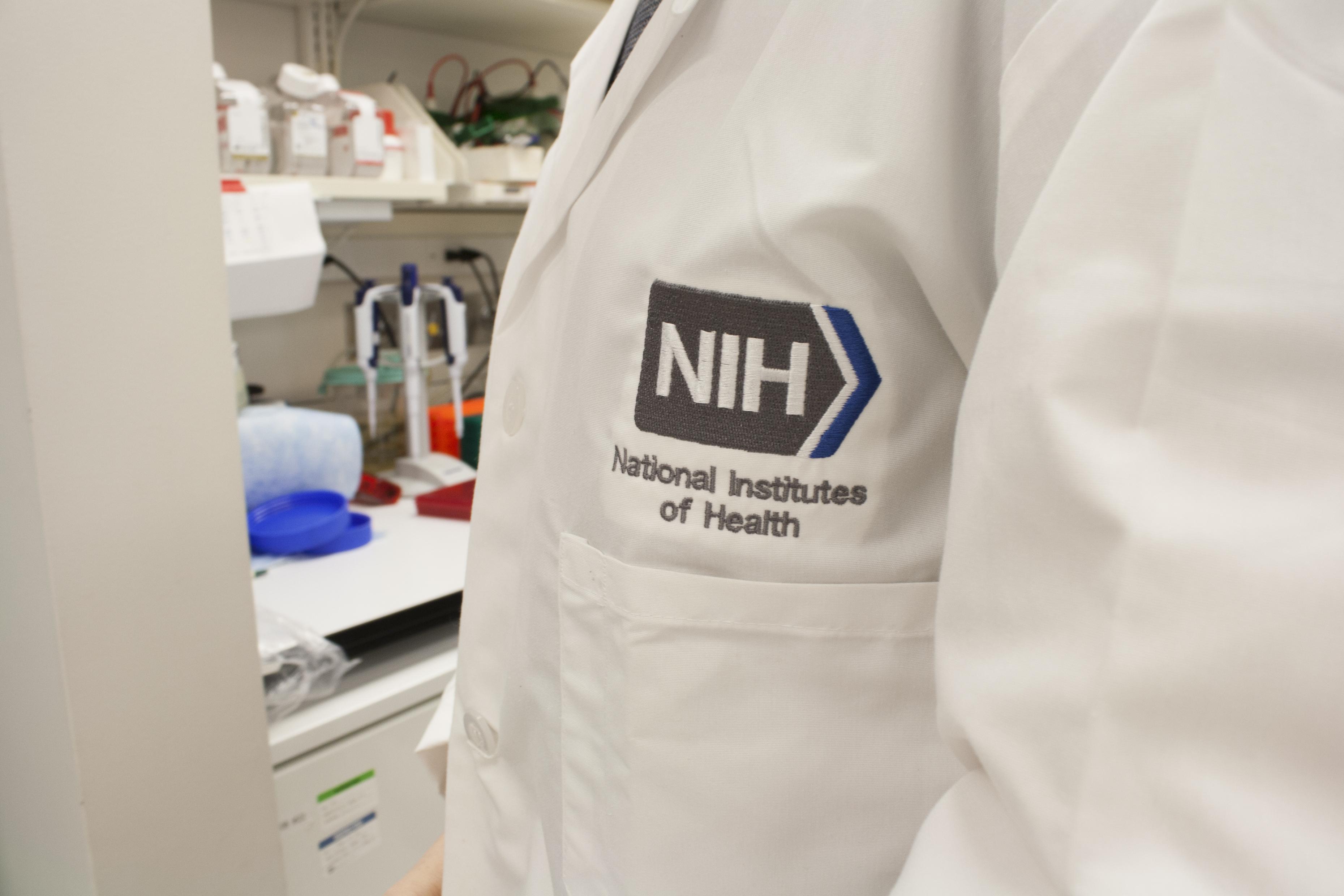 Person wearing NIH lab coat with logo