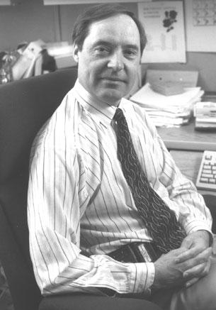 Old black and white photograph of investigator Ian Magrath in his office.