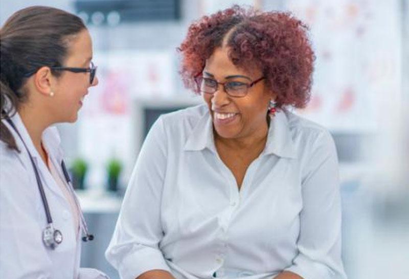 Stock image of doctor speaking with a patient as they both smile