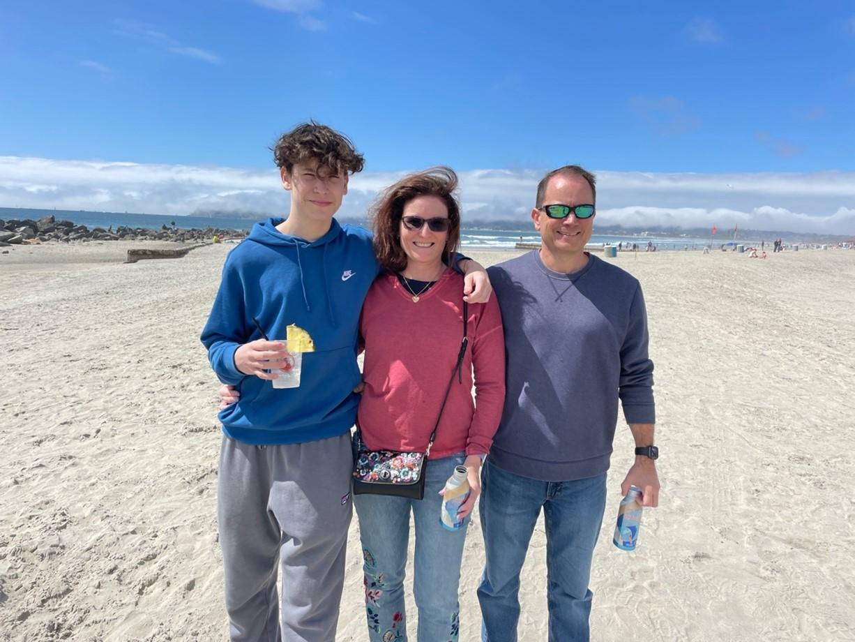 Alison with her son, Brett (left) and her husband, Don (right) at the beach.