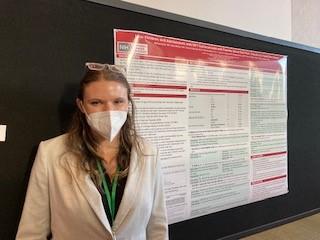 A team member presents her research at a conference poster presentation.