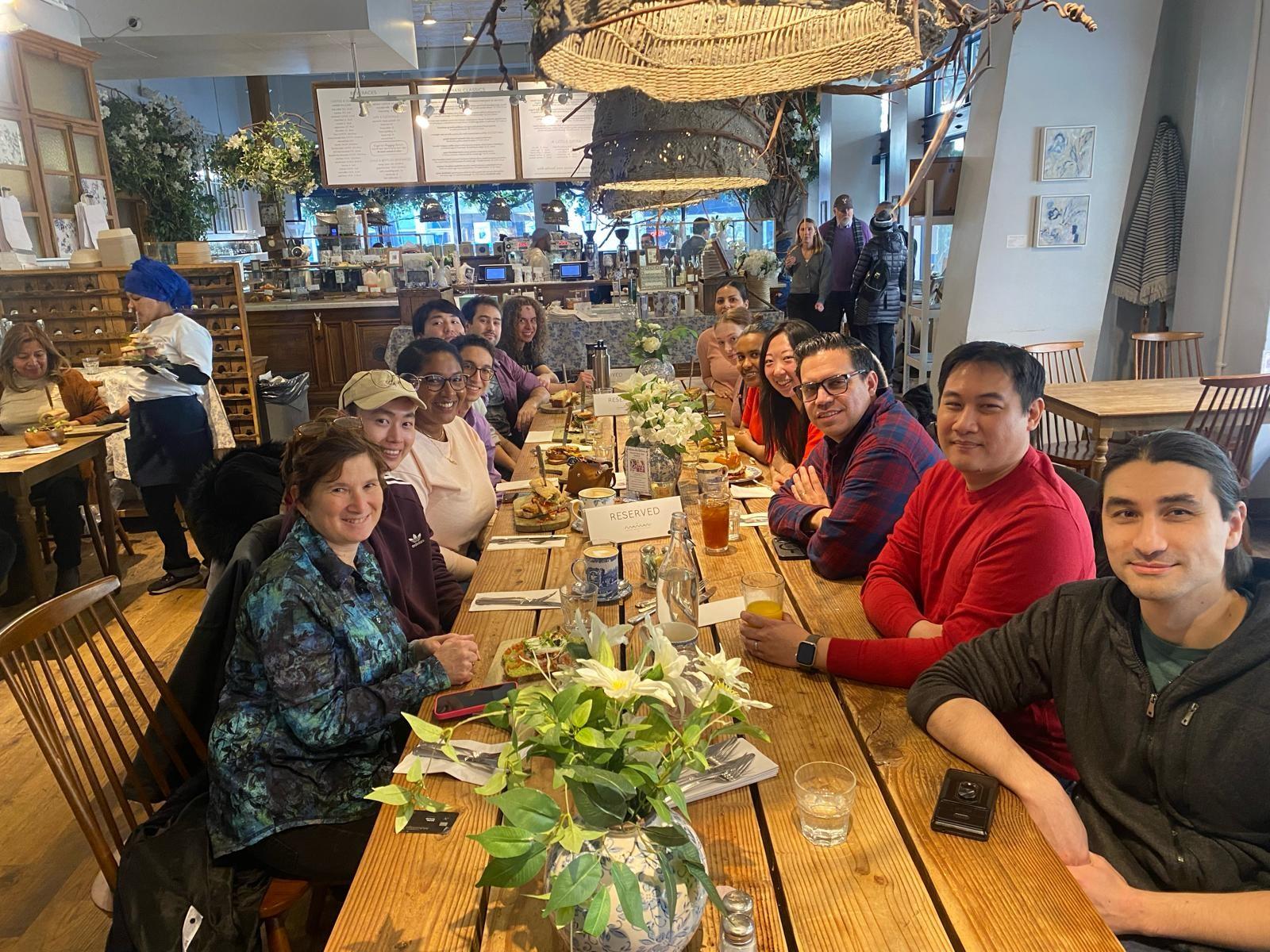 The group sits at a long table for lunch