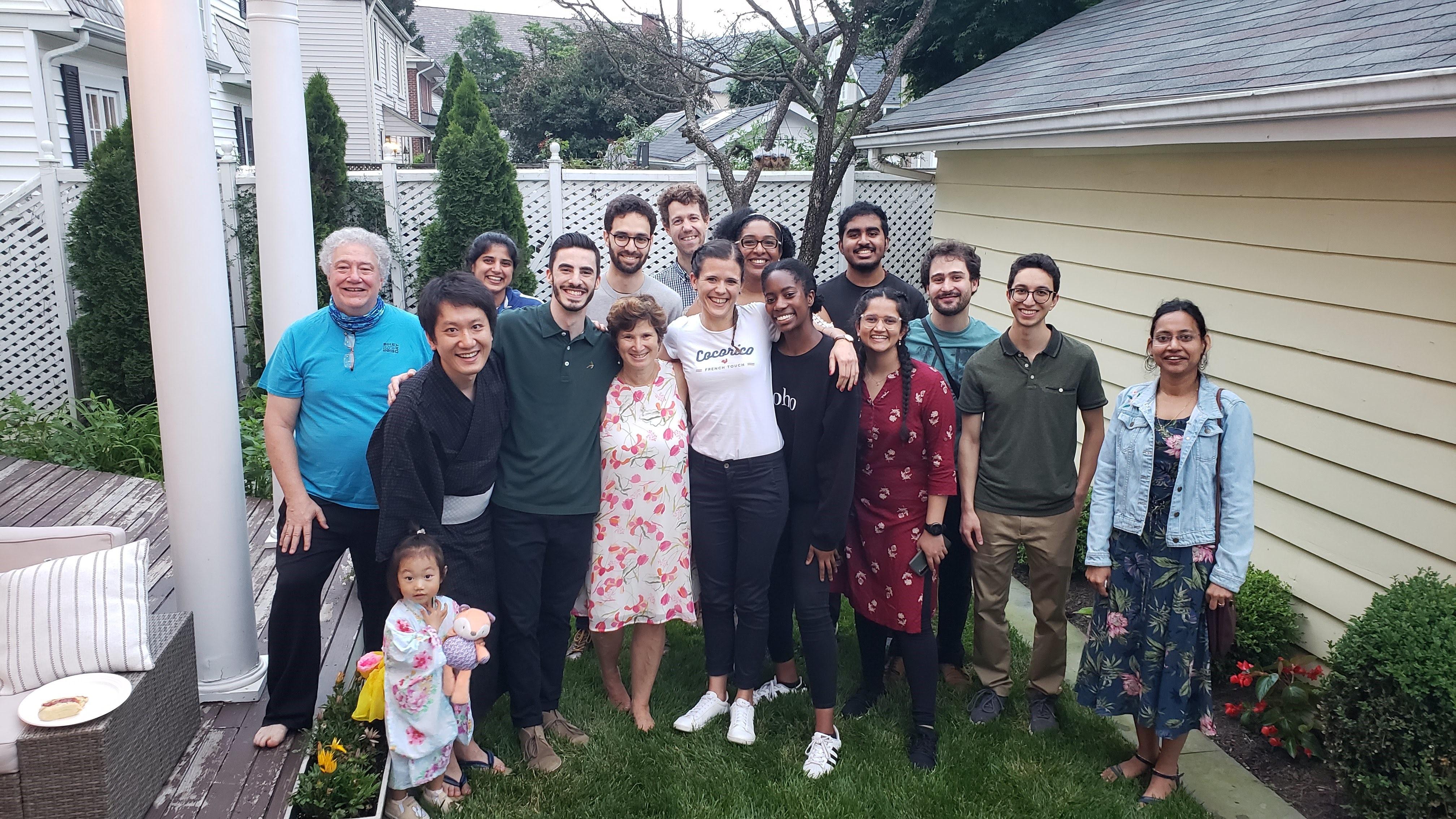 Members of the Taylor lab smile during a group gathering at a lab member’s home. Dr. Taylor is in the center of the photo.