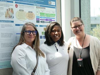 Postbac with her mentors in front of poster